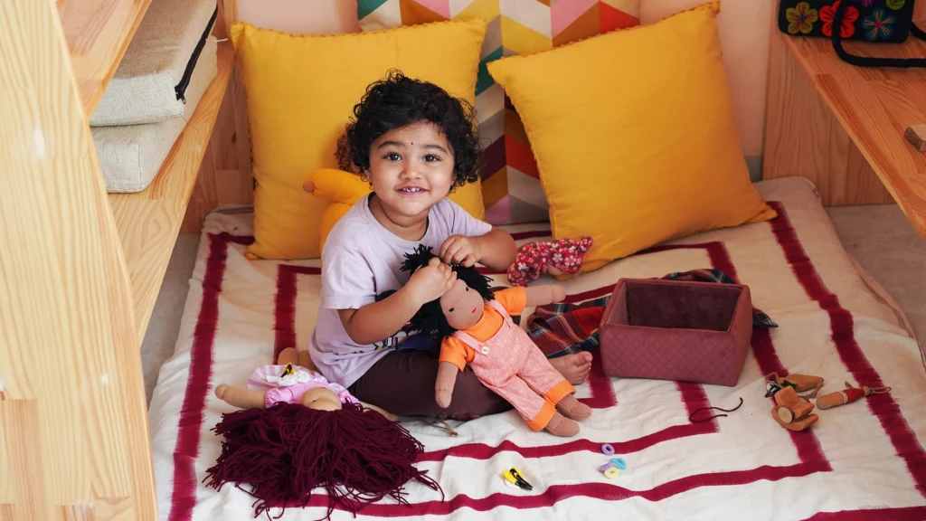 kid playing with waldorf doll