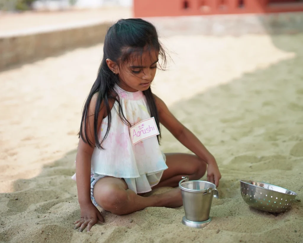 Kids playing in sand in thraya school